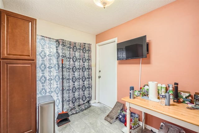 bathroom with tile patterned flooring and a textured ceiling