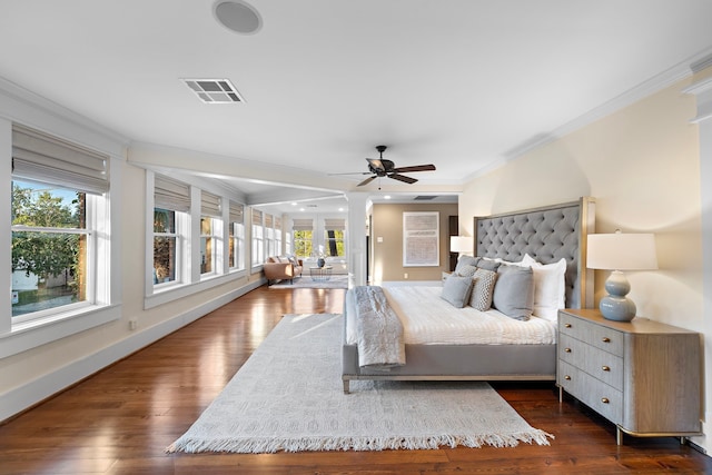 bedroom with crown molding, dark hardwood / wood-style floors, and ceiling fan