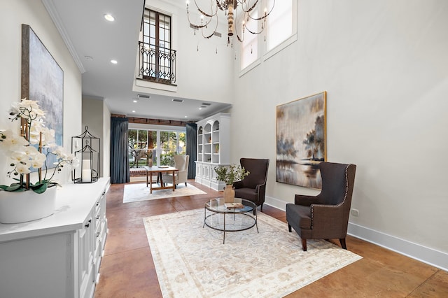 sitting room featuring a high ceiling, ornamental molding, concrete flooring, and a chandelier