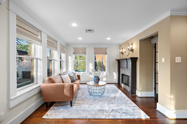 living room featuring crown molding, dark hardwood / wood-style floors, and a fireplace