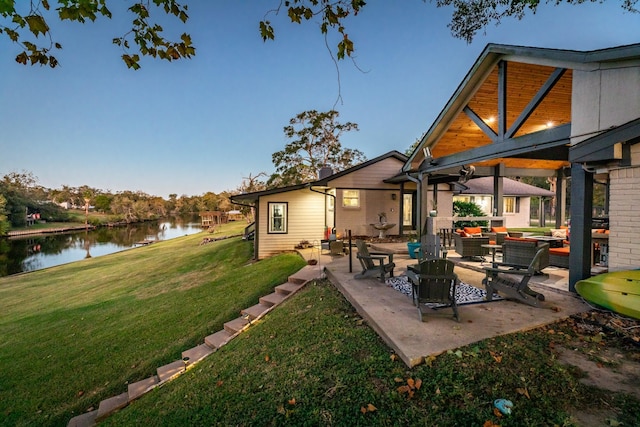 exterior space with a lawn, ceiling fan, an outdoor living space, a water view, and a patio area