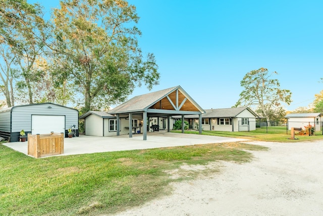 exterior space featuring an outbuilding, a yard, a garage, and a patio