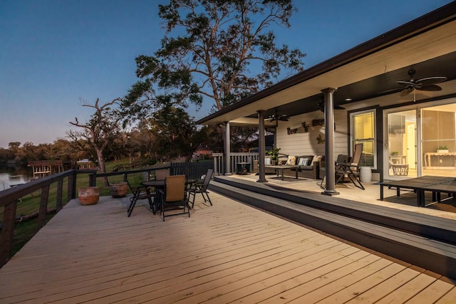 deck at dusk featuring ceiling fan