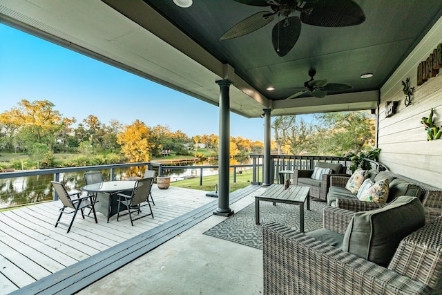 wooden deck featuring an outdoor hangout area, ceiling fan, and a water view