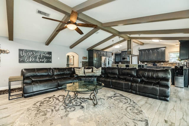 living room with lofted ceiling with beams, ceiling fan, and light wood-type flooring