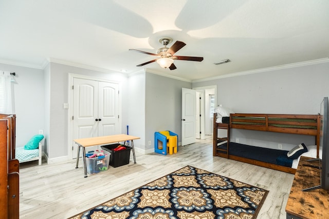 bedroom featuring crown molding, ceiling fan, a closet, and light wood-type flooring