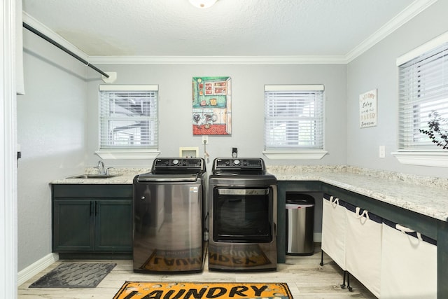 washroom with sink, cabinets, independent washer and dryer, ornamental molding, and light wood-type flooring