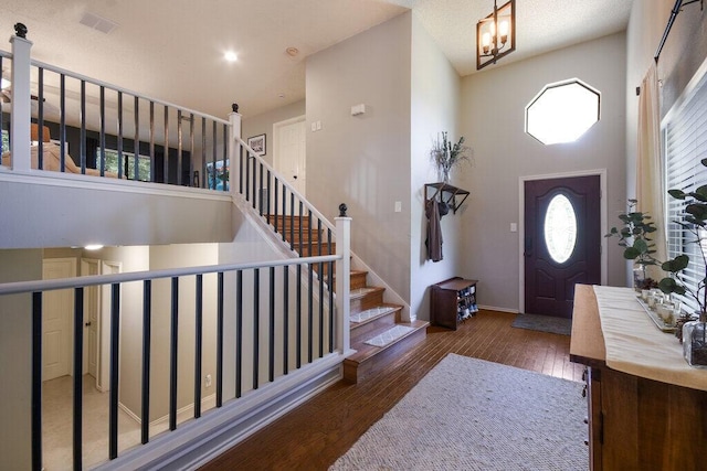 entryway with a towering ceiling and dark hardwood / wood-style flooring