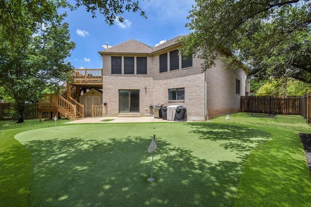 back of property featuring a shed, a deck, and a patio area