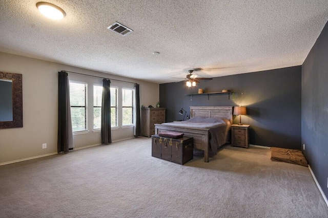 carpeted bedroom featuring a textured ceiling and ceiling fan