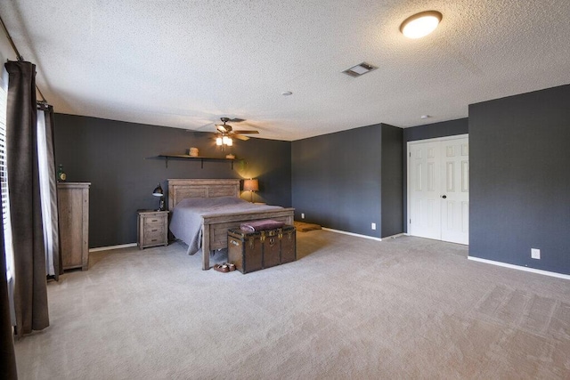 bedroom featuring ceiling fan, a textured ceiling, and carpet