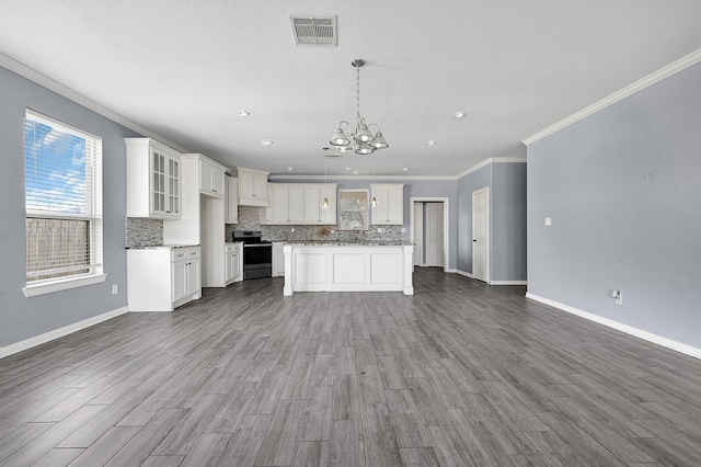 kitchen featuring tasteful backsplash, white cabinetry, hanging light fixtures, a center island, and electric stove