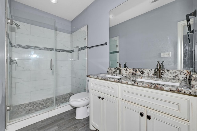 bathroom with hardwood / wood-style flooring, vanity, toilet, and an enclosed shower