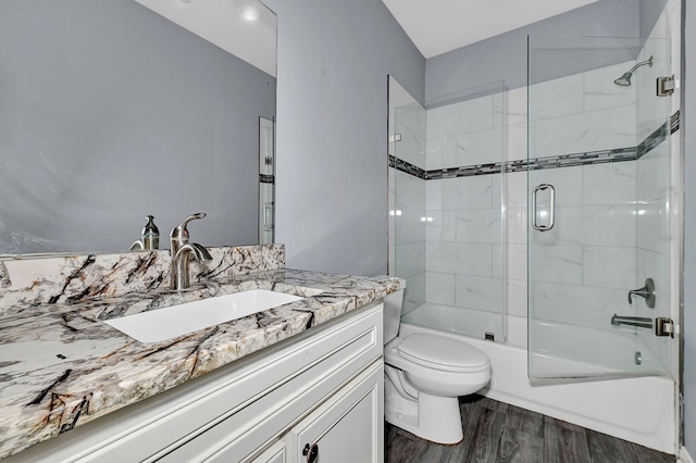 full bathroom with toilet, vanity, bath / shower combo with glass door, and hardwood / wood-style floors