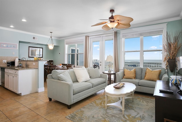 tiled living room featuring sink, plenty of natural light, and ornamental molding