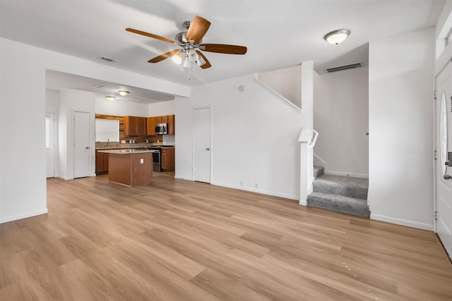 unfurnished living room with ceiling fan and light wood-type flooring