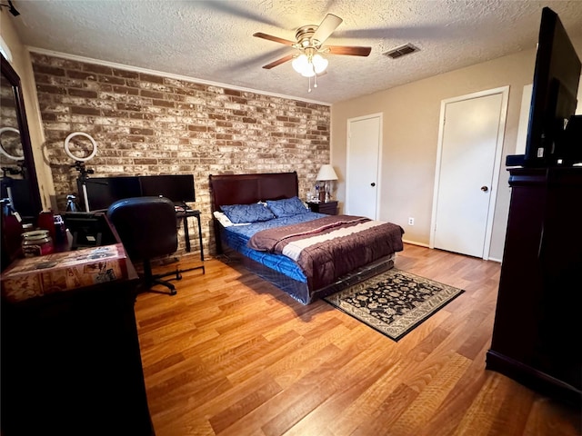 bedroom with ceiling fan, a textured ceiling, and light hardwood / wood-style floors