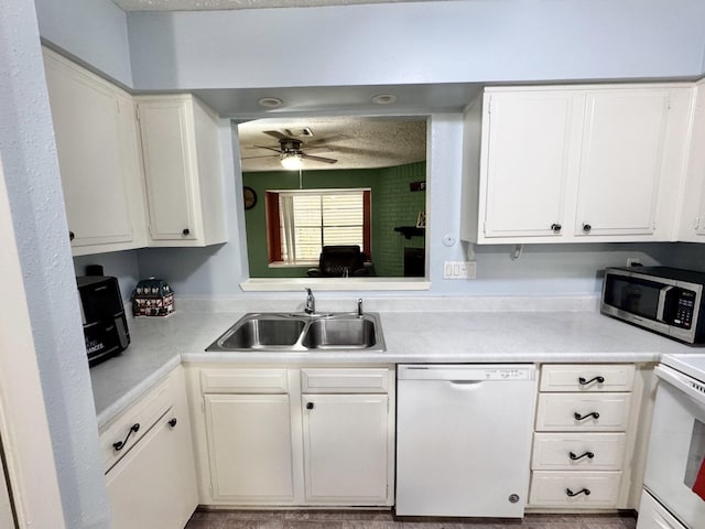 kitchen featuring white cabinets, white appliances, light countertops, and a sink