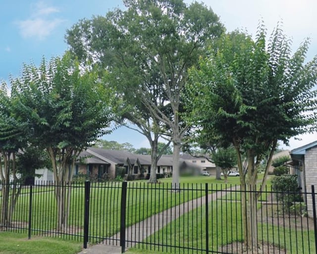 view of gate featuring a residential view, fence, and a yard