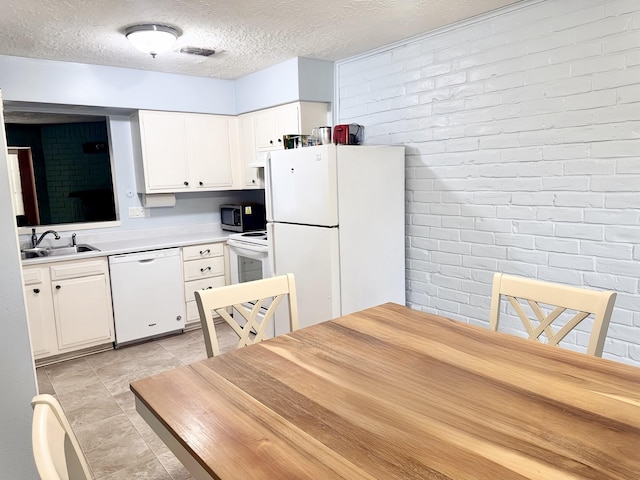 kitchen featuring light countertops, white appliances, a sink, and white cabinets