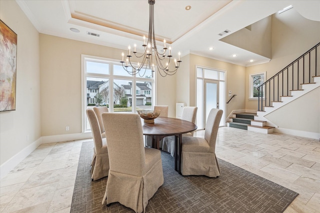 dining room with a raised ceiling, ornamental molding, and a healthy amount of sunlight