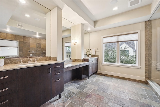 bathroom featuring vanity, a tray ceiling, and plenty of natural light