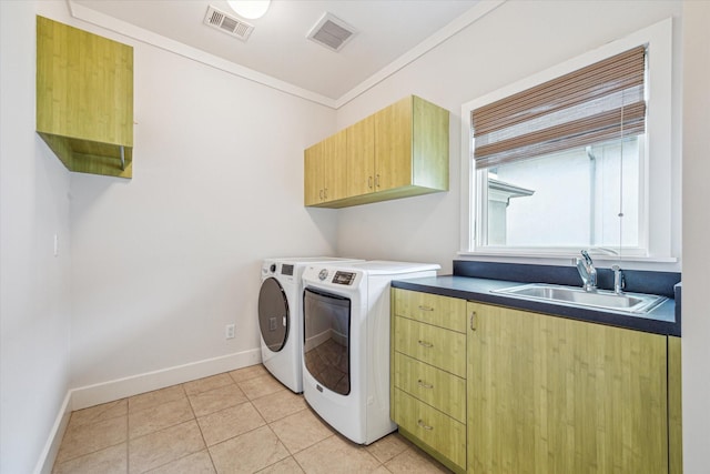 clothes washing area featuring sink, crown molding, cabinets, light tile patterned floors, and independent washer and dryer