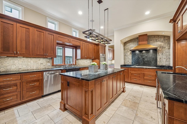 kitchen featuring pendant lighting, sink, appliances with stainless steel finishes, a kitchen island, and wall chimney exhaust hood