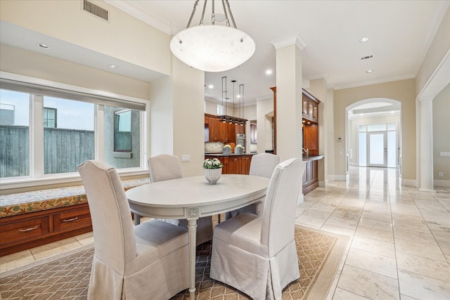 dining room featuring ornamental molding and decorative columns