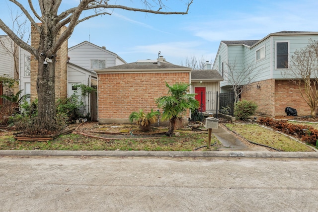 1912 Trixie Ln, Houston, TX 77042 - view of front of property featuring brick siding, solar panels, and a shingled roof