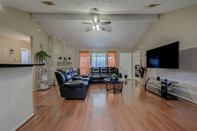 living room featuring hardwood / wood-style floors, vaulted ceiling with beams, a textured ceiling, and ceiling fan