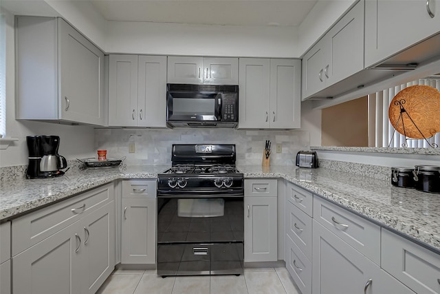 kitchen featuring backsplash, gray cabinets, black appliances, and light tile patterned flooring