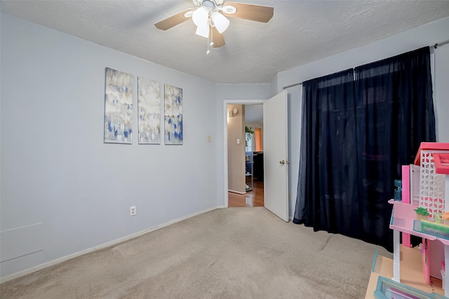 interior space with ceiling fan, carpet, and a textured ceiling