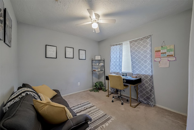 office space featuring ceiling fan, light colored carpet, and a textured ceiling