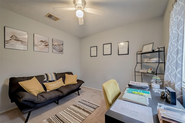 carpeted office with a textured ceiling and ceiling fan