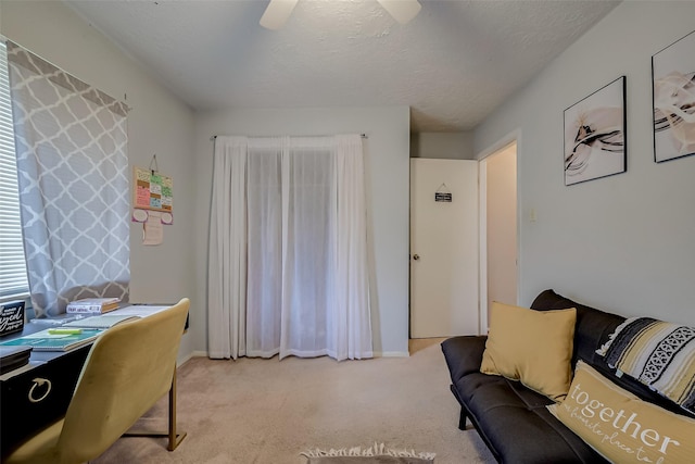 carpeted office with ceiling fan and a textured ceiling