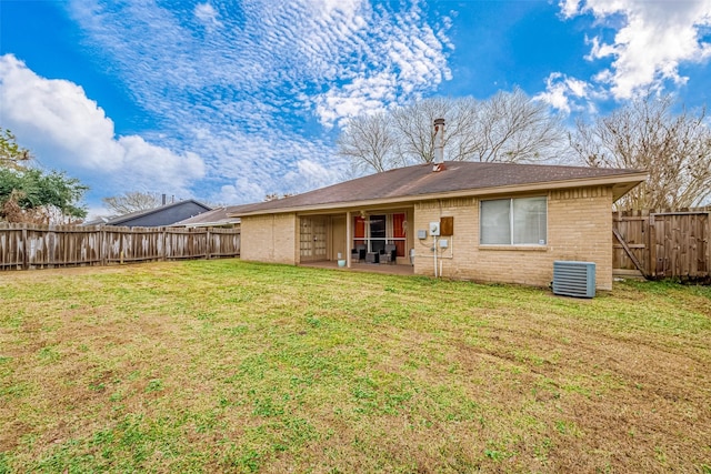 rear view of property with a yard, central AC unit, and a patio