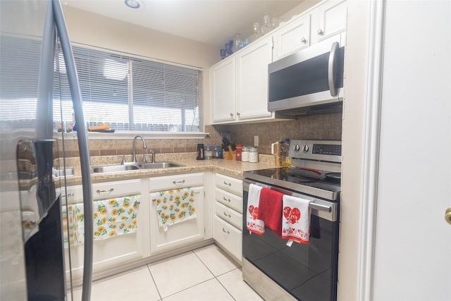 kitchen with sink, light tile patterned floors, stainless steel appliances, decorative backsplash, and white cabinets