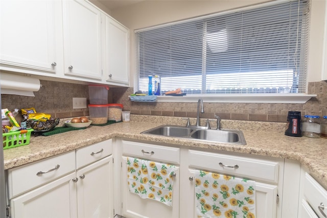 kitchen with white cabinetry, sink, and decorative backsplash