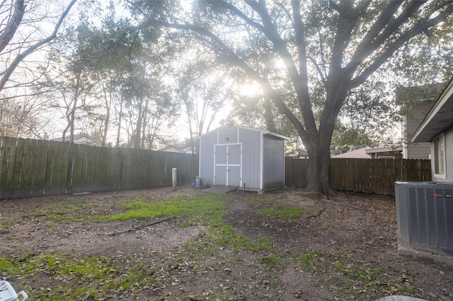 view of yard with central AC unit and a shed