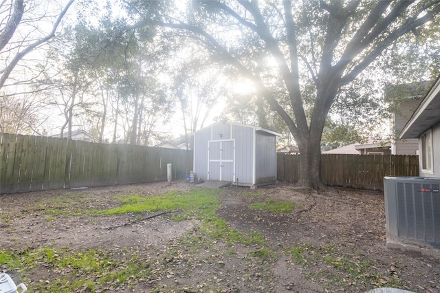 view of yard featuring central air condition unit and a storage unit