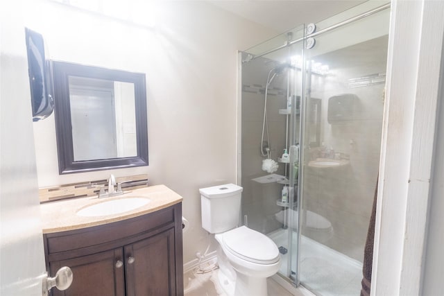 bathroom with vanity, a shower with shower door, and toilet