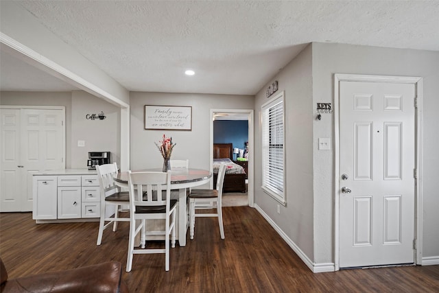 dining area featuring dark hardwood / wood-style floors and a textured ceiling