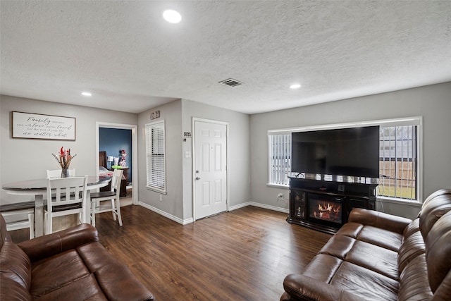 living room featuring dark hardwood / wood-style floors and a textured ceiling