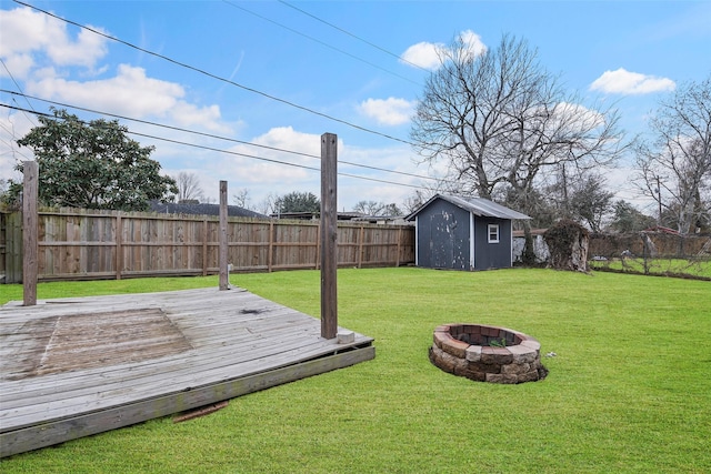 view of yard with a wooden deck, an outdoor fire pit, and a storage unit