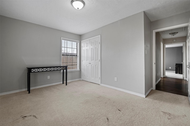 unfurnished bedroom featuring a closet, carpet floors, and a textured ceiling