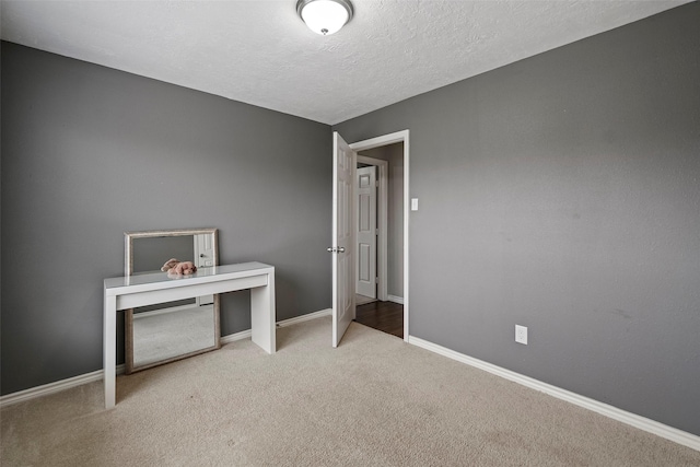 unfurnished bedroom with light carpet and a textured ceiling