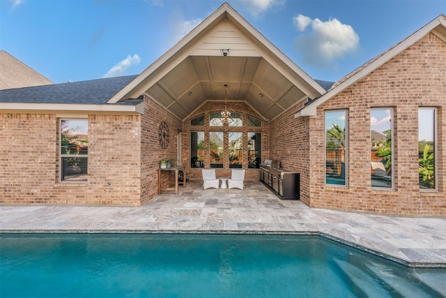 view of swimming pool with a patio and an outdoor kitchen