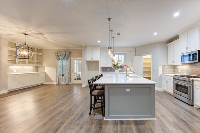 kitchen with a kitchen island with sink, stainless steel appliances, and white cabinets