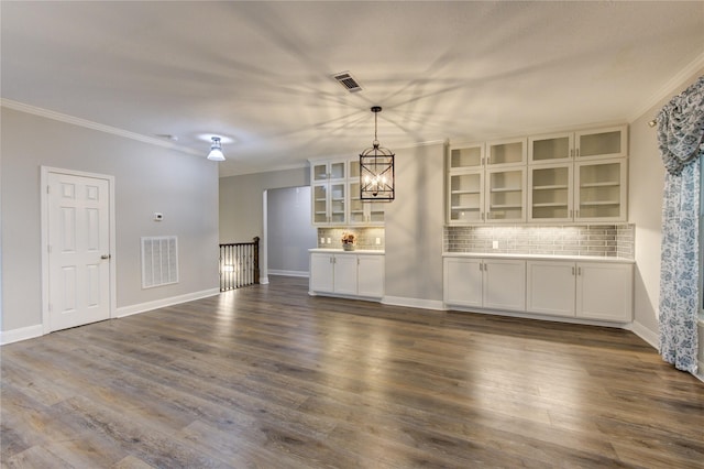 interior space featuring crown molding, dark hardwood / wood-style flooring, and an inviting chandelier